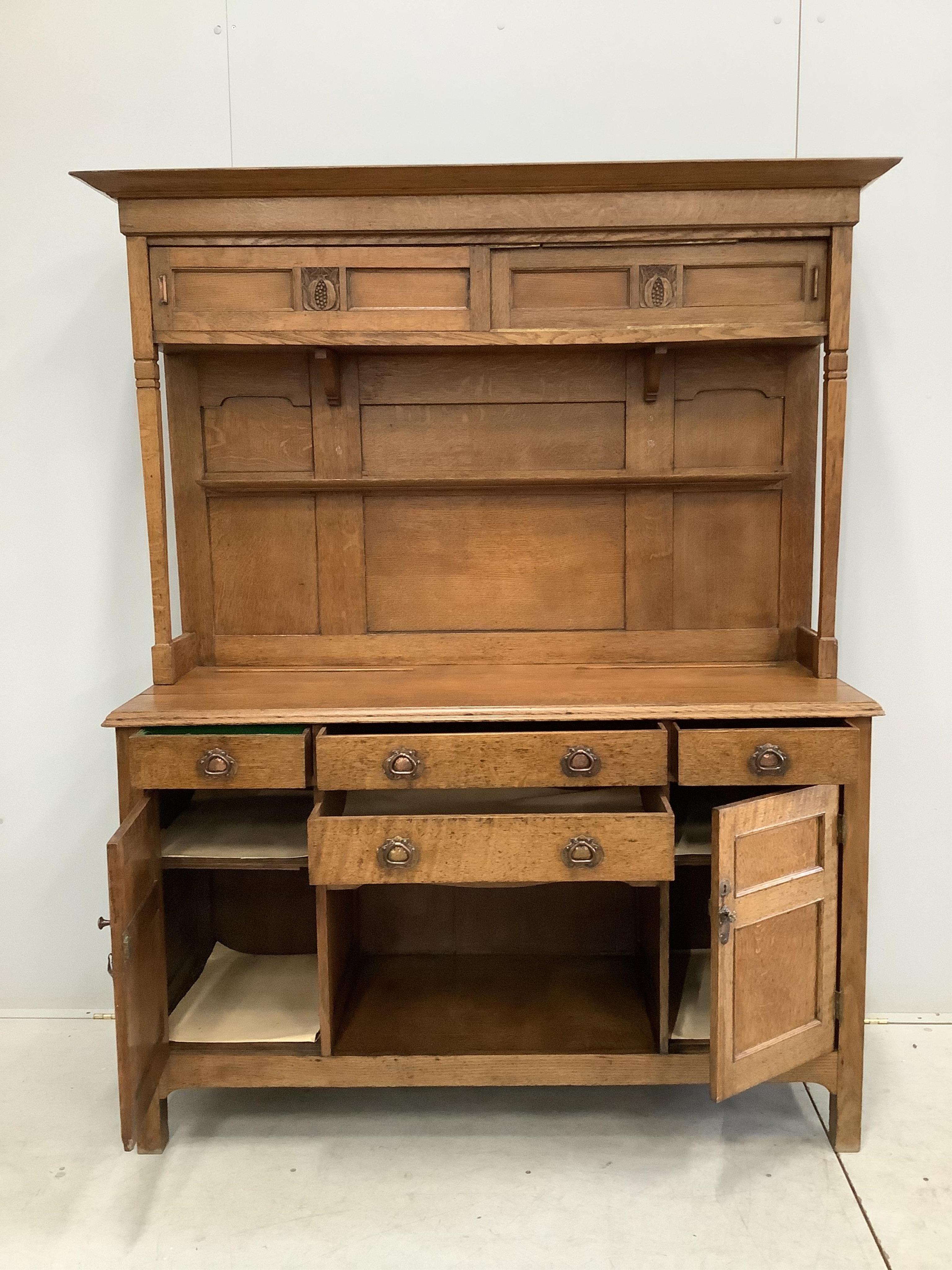 A small Arts & Crafts copper mounted oak dresser, width 140cm, depth 48cm, height 182cm. Condition - fair